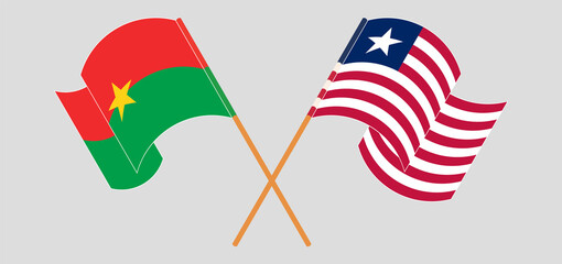Crossed and waving flags of Burkina Faso and Liberia