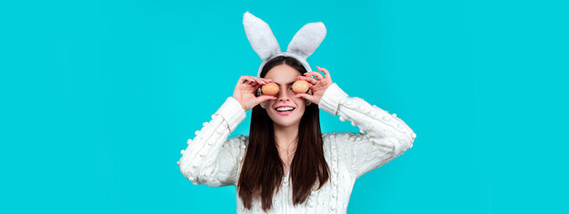 Easter banner. Funny woman wearing bunny ears and having fun with Easter eggs. Playing hunt eggs. Happy Easter concept.