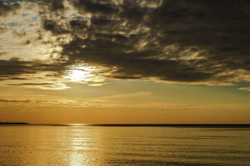 Sunset over the sea. Reflection of sunlight in the sea waves. The sky in the sunset rays. Baltic Sea.
