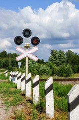 Red traffic light at the railway crossing. Warning sign before the railway crossing. Vertically....
