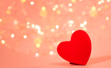 Red heart on pink background with bokeh. 