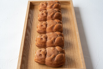 木のトレイに5つ並んだたぬきの人形焼き