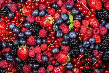 Various fresh summer berries backgrounds. Strawberry, blueberry, raspberry red currant and blackberry mix. Top view, flat lay.