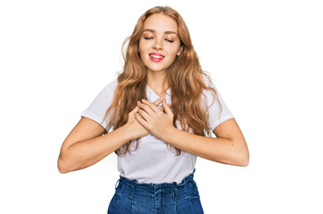 Young caucasian girl wearing casual white t shirt smiling with hands on chest with closed eyes and grateful gesture on face. health concept.