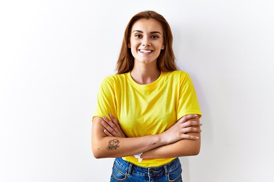 Young brunette woman standing over isolated background happy face smiling with crossed arms looking at the camera. positive person.
