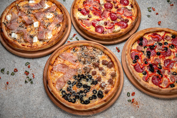 Pizza party dinner. Flat-lay of different kinds of Tasty hot Italian pizza on a beige textured background. Fast food lunch, gathering, celebration. Pizzeria 
