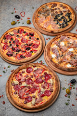 Pizza party dinner. Flat-lay of different kinds of Tasty hot Italian pizza on a beige textured background. Fast food lunch, gathering, celebration. Pizzeria 