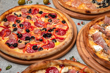 Pizza party dinner. Flat-lay of different kinds of Tasty hot Italian pizza on a beige textured background. Fast food lunch, gathering, celebration. Pizzeria 