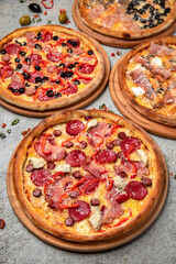 Pizza party dinner. Flat-lay of different kinds of Tasty hot Italian pizza on a beige textured background. Fast food lunch, gathering, celebration. Pizzeria 