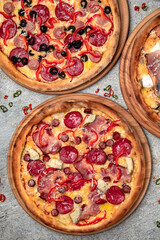 Pizza party dinner. Flat-lay of different kinds of Tasty hot Italian pizza on a beige textured background. Fast food lunch, gathering, celebration. Pizzeria 