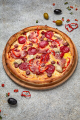 Tasty hot italian pizza with Mozzarella, Pepperoni, pastrami, hunting sausages and Tomato Sauce on a beige textured background. Pizzeria menu. 