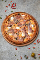 Tasty hot italian pizza with Mozzarella, Prosciutto, fried mushrooms and Tomato Sauce on a beige textured background. Pizzeria menu. 