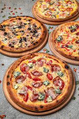 Pizza party dinner. Flat-lay of different kinds of Tasty hot Italian pizza on a beige textured background. Fast food lunch, gathering, celebration. Pizzeria 