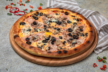 Tasty hot italian pizza with Mozzarella, Ham, mushrooms, olives and Tomato Sauce on a beige textured background. Pizzeria menu. 
