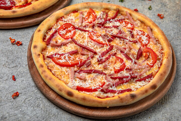 Tasty hot italian pizza with Mozzarella, Salami, ham, sweet pepper and Tomato Sauce on a beige textured background. Pizzeria menu. 