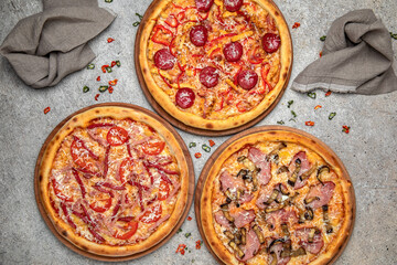 Pizza party dinner. Flat-lay of different kinds of Tasty hot Italian pizza on a beige textured background. Fast food lunch, gathering, celebration. Pizzeria 