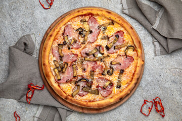 Tasty hot italian pizza with Mozzarella, Ham, Mushrooms and Tomato Sauce on a beige textured background. Pizzeria menu. 