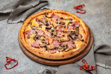 Tasty hot italian pizza with Mozzarella, Ham, Mushrooms and Tomato Sauce on a beige textured background. Pizzeria menu. 
