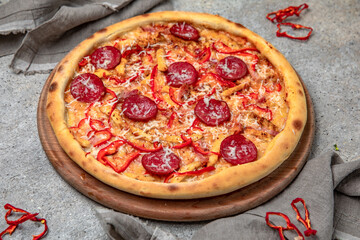 Tasty hot italian pizza with Mozzarella, Pepperoni, sweet pepper and Tomato Sauce on a beige textured background. Pizzeria menu. 