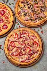 Pizza party dinner. Flat-lay of different kinds of Tasty hot Italian pizza on a beige textured background. Fast food lunch, gathering, celebration. Pizzeria 