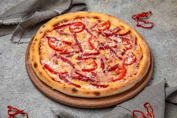 Tasty hot italian pizza with Mozzarella, Salami, ham, sweet pepper and Tomato Sauce on a beige textured background. Pizzeria menu. 