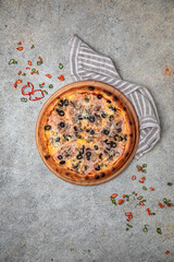 Tasty hot italian pizza with Mozzarella, Ham, mushrooms, olives and Tomato Sauce on a beige textured background. Pizzeria menu. 
