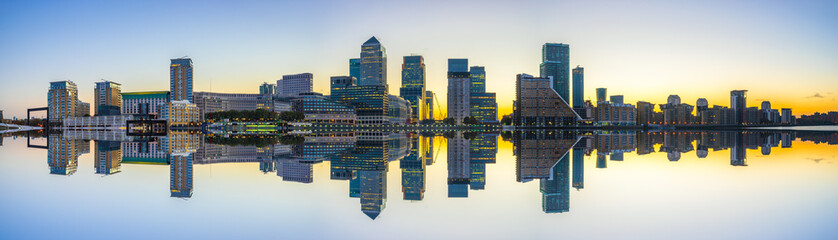 Canary Wharf panorama with reflection at sunrise in London. England