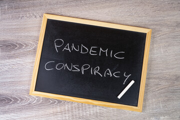 pandemic conspiracy written with chalk on a blackboard