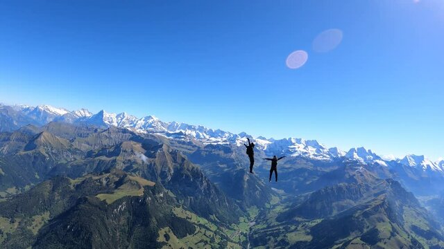 Sky divers free fall above mountain landscape