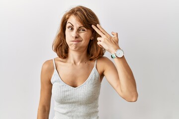 Fototapeta premium Beautiful caucasian woman standing over isolated background shooting and killing oneself pointing hand and fingers to head like gun, suicide gesture.