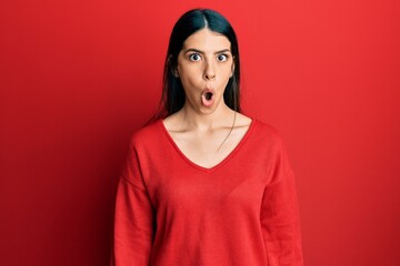 Young hispanic woman wearing casual clothes scared and amazed with open mouth for surprise,...