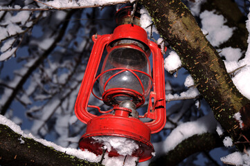 The old metal red lantern in the snow