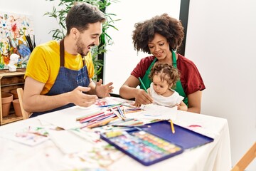 Couple and daughter smiling confident drawing at art studio