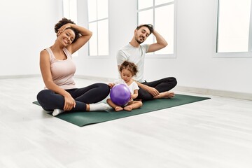 Fototapeta na wymiar Couple and daughter smiling confident stretching at sport center