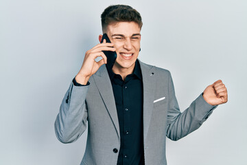 Young caucasian boy with ears dilation having conversation talking on the smartphone screaming proud, celebrating victory and success very excited with raised arm