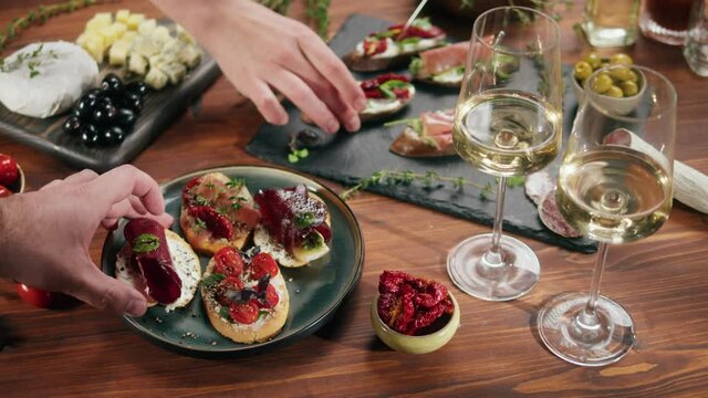 Italian restaurant with traditional food, Spanish cuisine, delicious tapas and white wine, bruschetta with cheese, olives dry tomatoes and tasty sandwich bar appetizer, buffet high cuisine table