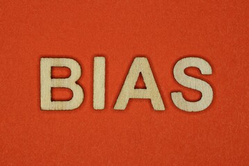 text the word bias from gray wooden small letters on an red table