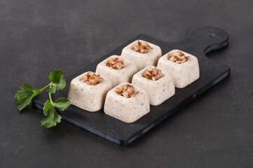 Vegan Cereal mini snack, Buckwheat cream jelly in the form of small portions of a cube shape on a serving board on a dark gray background