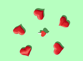 Red heart pillows on green pastel background