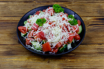 Traditional Bulgarian Shopska salad on wooden table