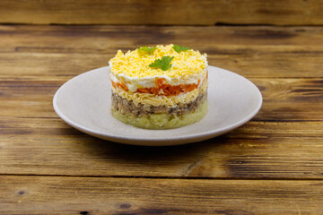 Traditional russian salad Mimosa on wooden table