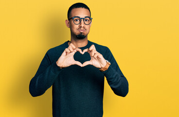 Young african american man doing heart symbol with hands puffing cheeks with funny face. mouth inflated with air, catching air.
