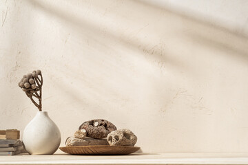 Home decor. Decorative stones against bright beige wall with sunlight and shadows.	