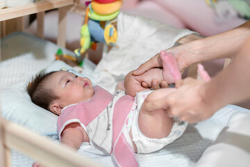 Parent help asian baby for burp by cycling massage technique, Burping babyconcept;