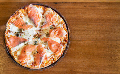 pizza with smoked salmon on wooden table