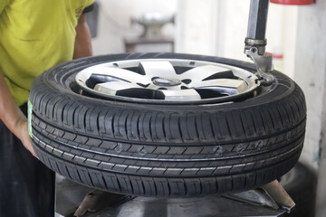 Wheel balancing or repair and change car tire at auto service garage or workshop by mechanic