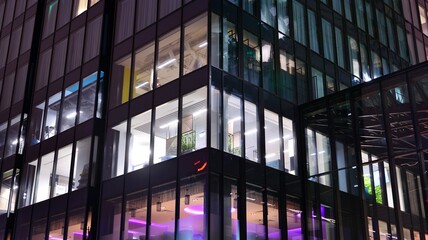 Office building at night, building facade with glass and lights. View with illuminated modern skyscraper.