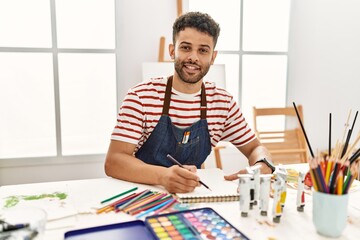 Young arab artist man smiling happy drawing at art studio.