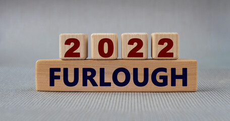 FURLOUGH 2022 - words on wooden cubes on a gray background