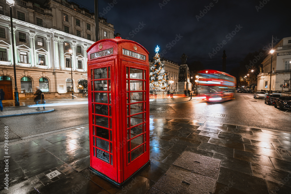 Sticker Christmas time in London with red telephone booth in front of an illuminated Christmas Tree